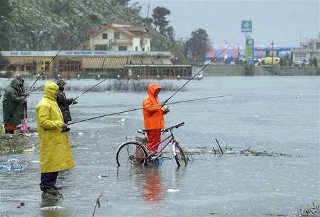 Albánci rybaří na rozvodněné řece.